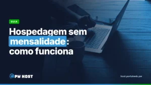 Hospedagem sem mensalidade: como funciona. Foto: mãos digitando em um notebook, com uma caneca e um celular sobre a mesa de madeira.